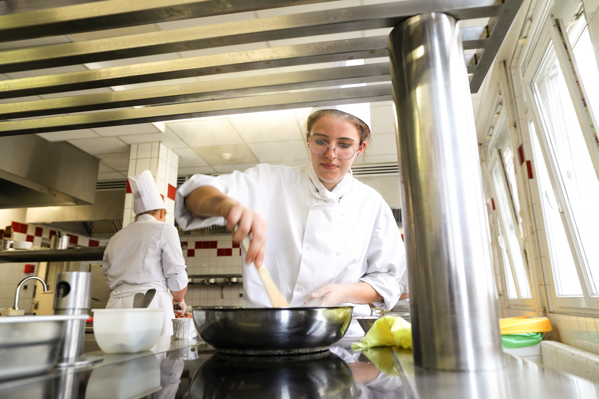 Une apprentie cuisinière au fourneau, dans la cuisine pédagogique du CFA